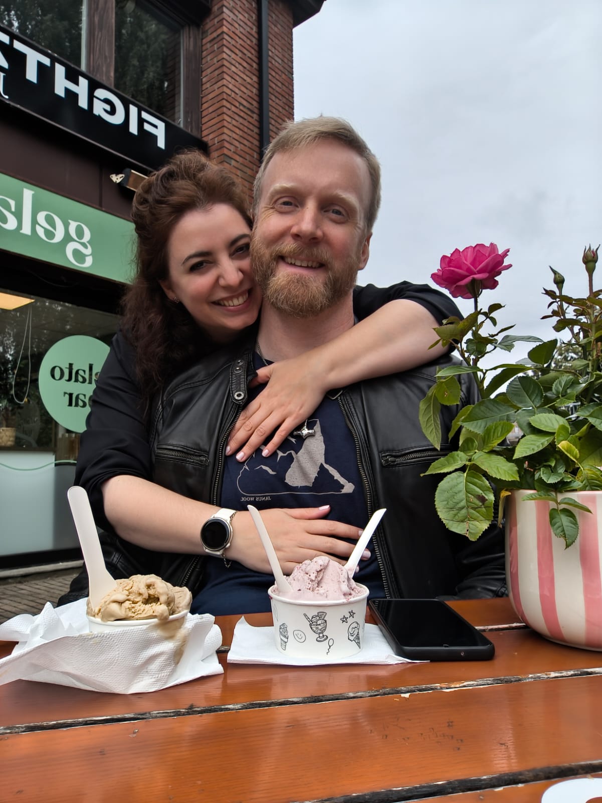 Stella and Roy smiling together at an outdoor café table